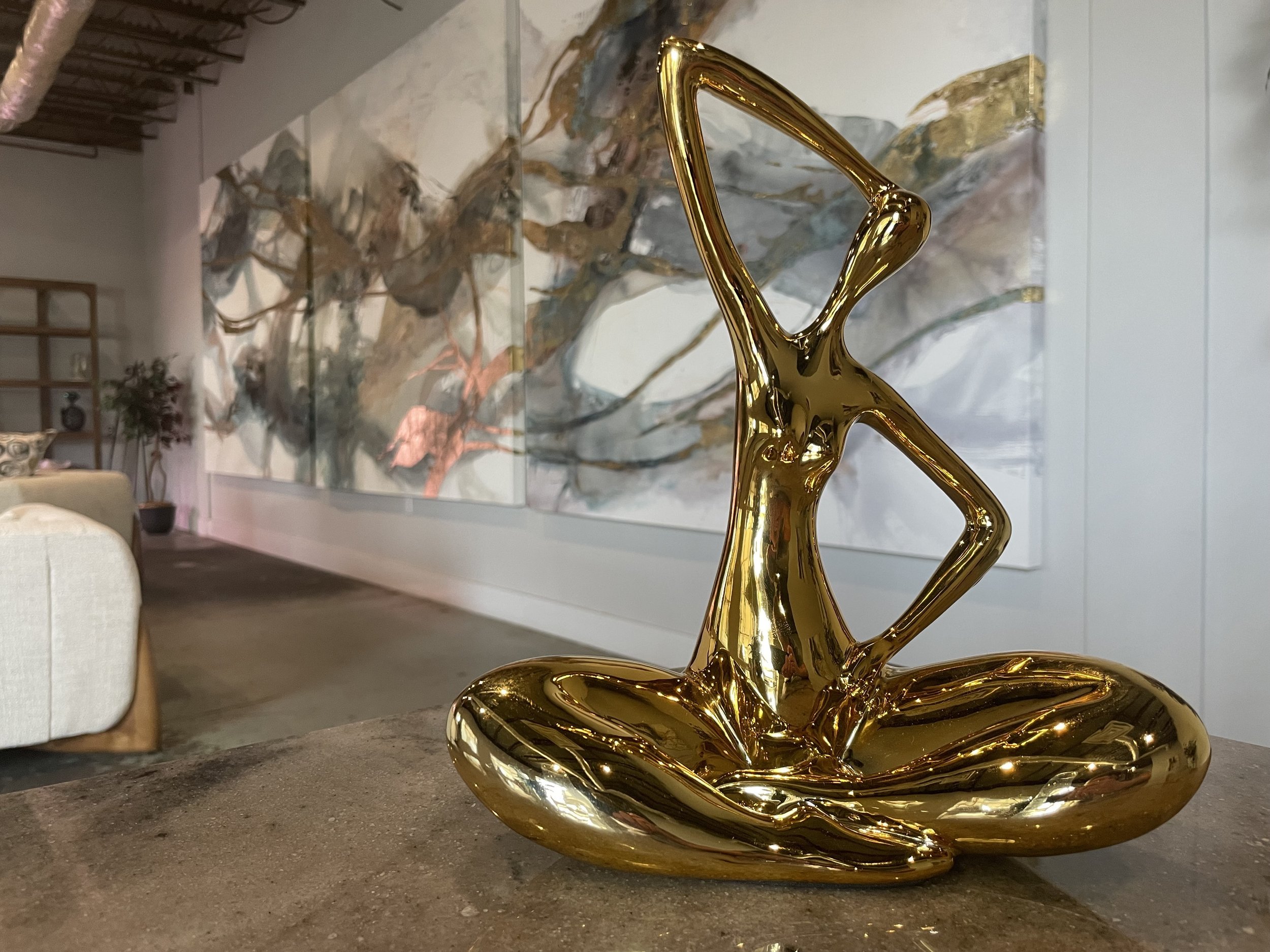 Polished gold modern yoga sculpture on display shelf