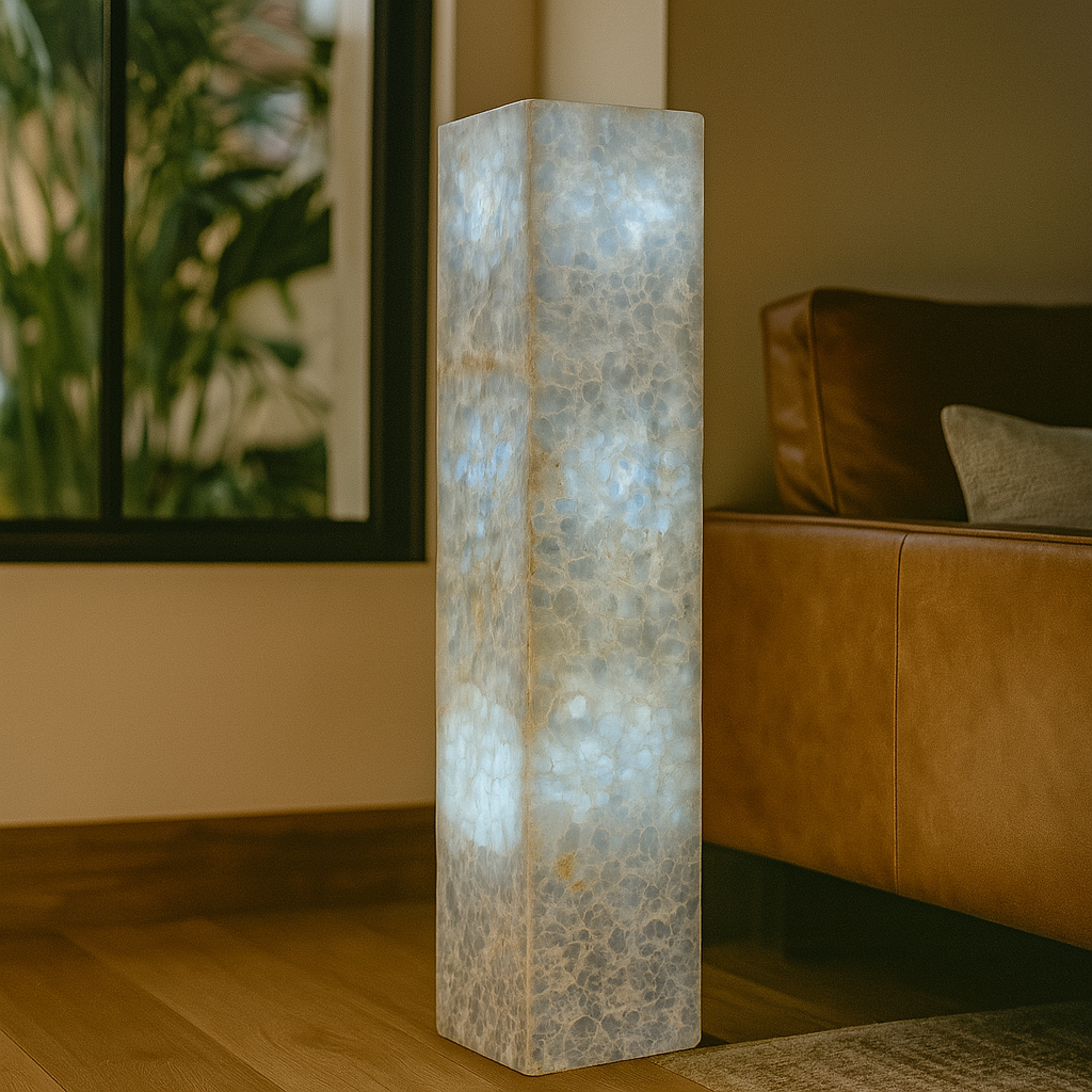 Translucent calcite tower floor lamp casting soft blue glow in modern living room