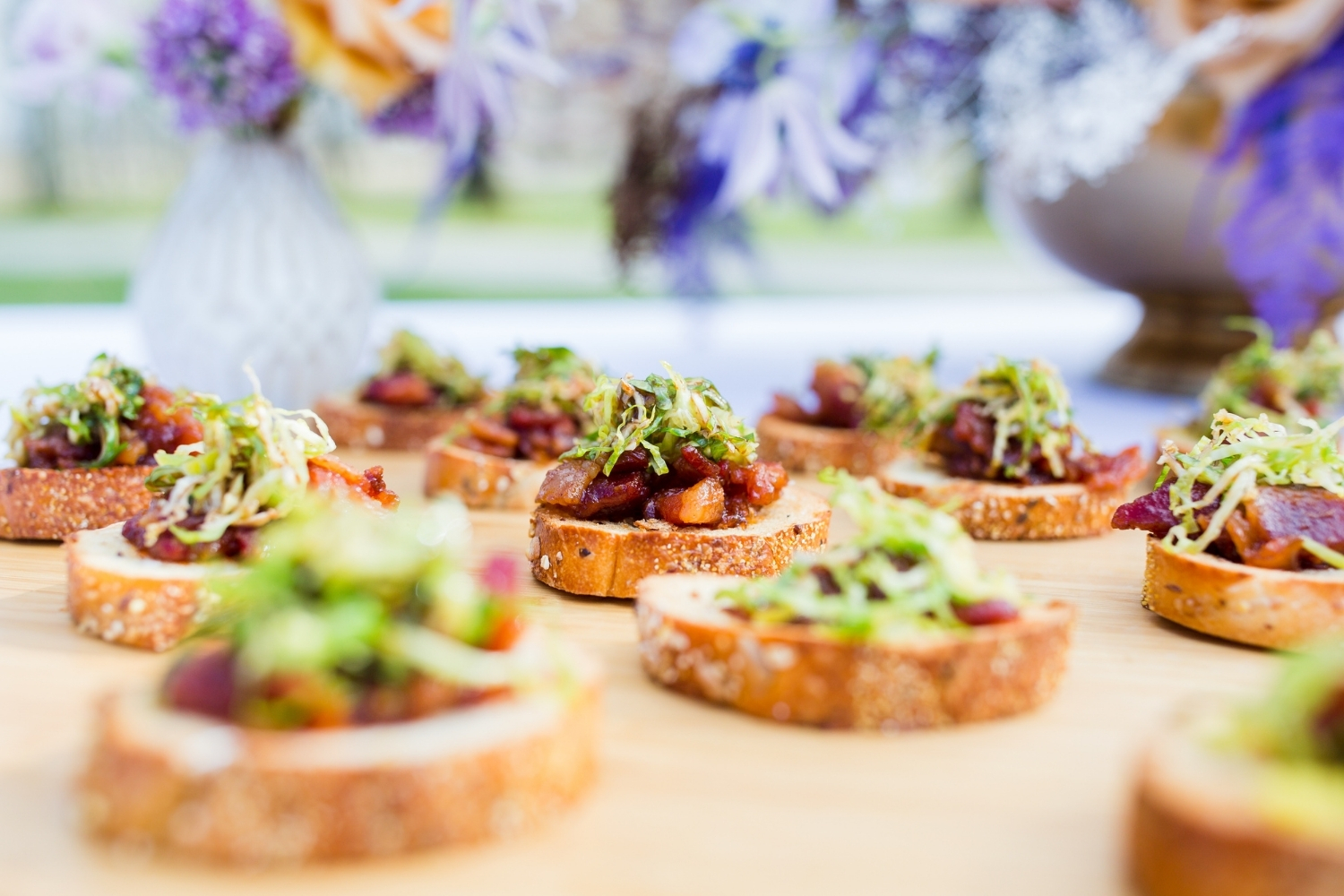 A delicious spread of crunchy crostini Hors D'oeuvres topped with roasted seasonal tomatoes and fresh herbs.
