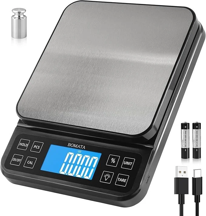 Digital pocket scale with a blue backlit display, two AA batteries, a small metal weight, and a USB charging cable.