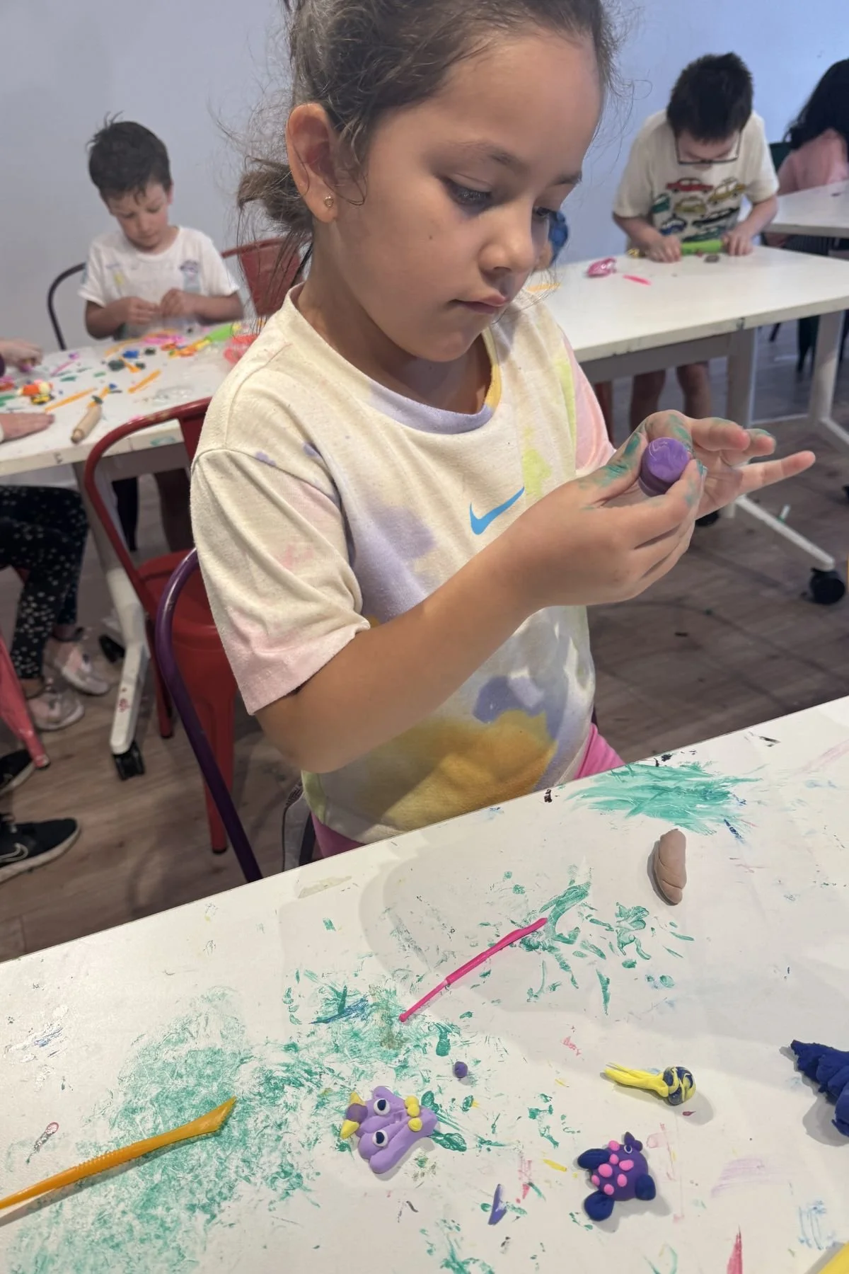Child sculpting clay creatures during a hands-on kids art class in Beaverton