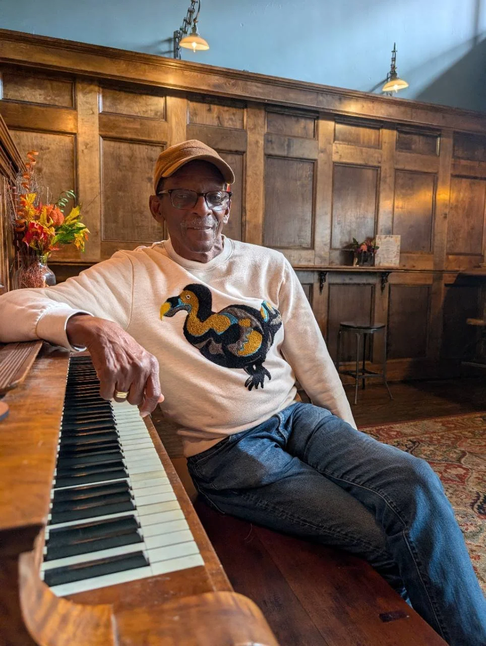 René Dickerson seated beside the piano at Black Iris in Richmond