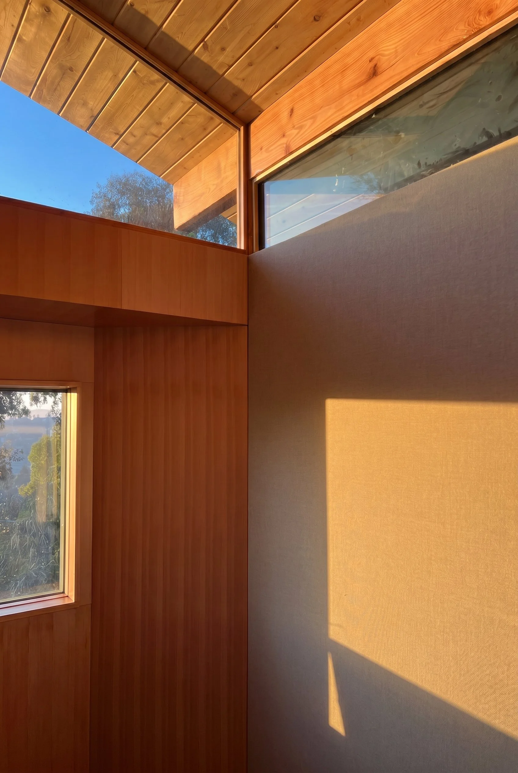 The interior palette combines Douglas fir, Guilford of Maine fabric, and soft natural light to create a listening-room atmosphere inspired by mid-century hi-fi design.