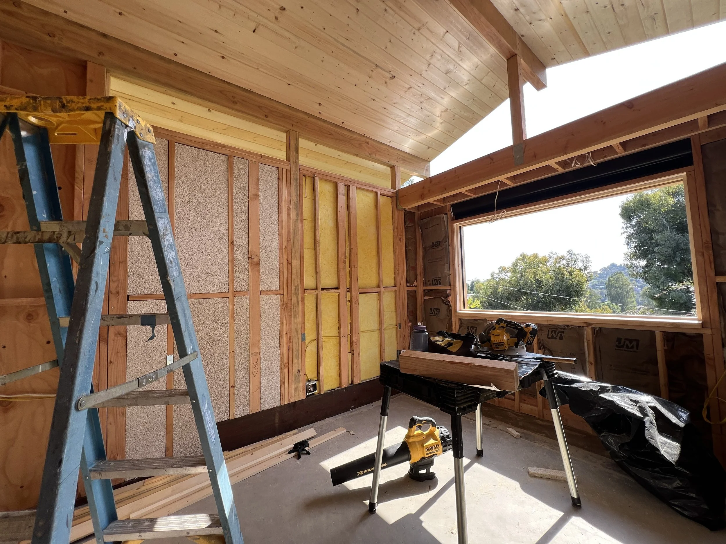 During construction, the studio's integrated acoustic system is visible within the wall assembly, where insulation, absorptive panels, and tuned geometries are built directly into the architecture rather than applied as a separate layer.