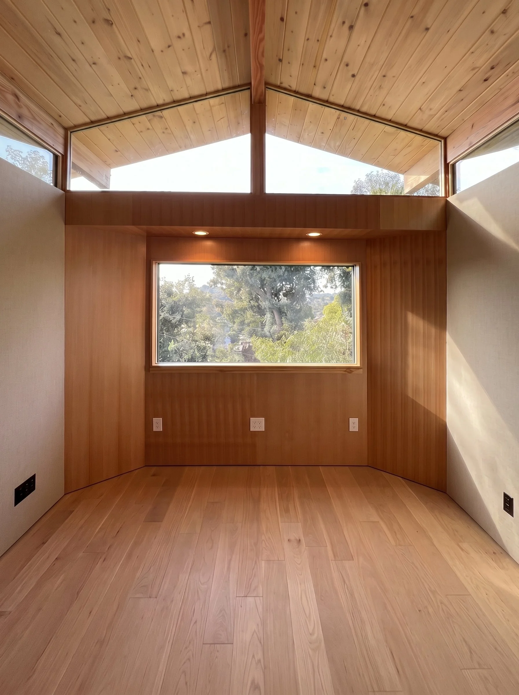 The primary writing space is oriented toward panoramic views of the Silver Lake Reservoir, while clerestory glazing introduces soft daylight without compromising acoustic performance.