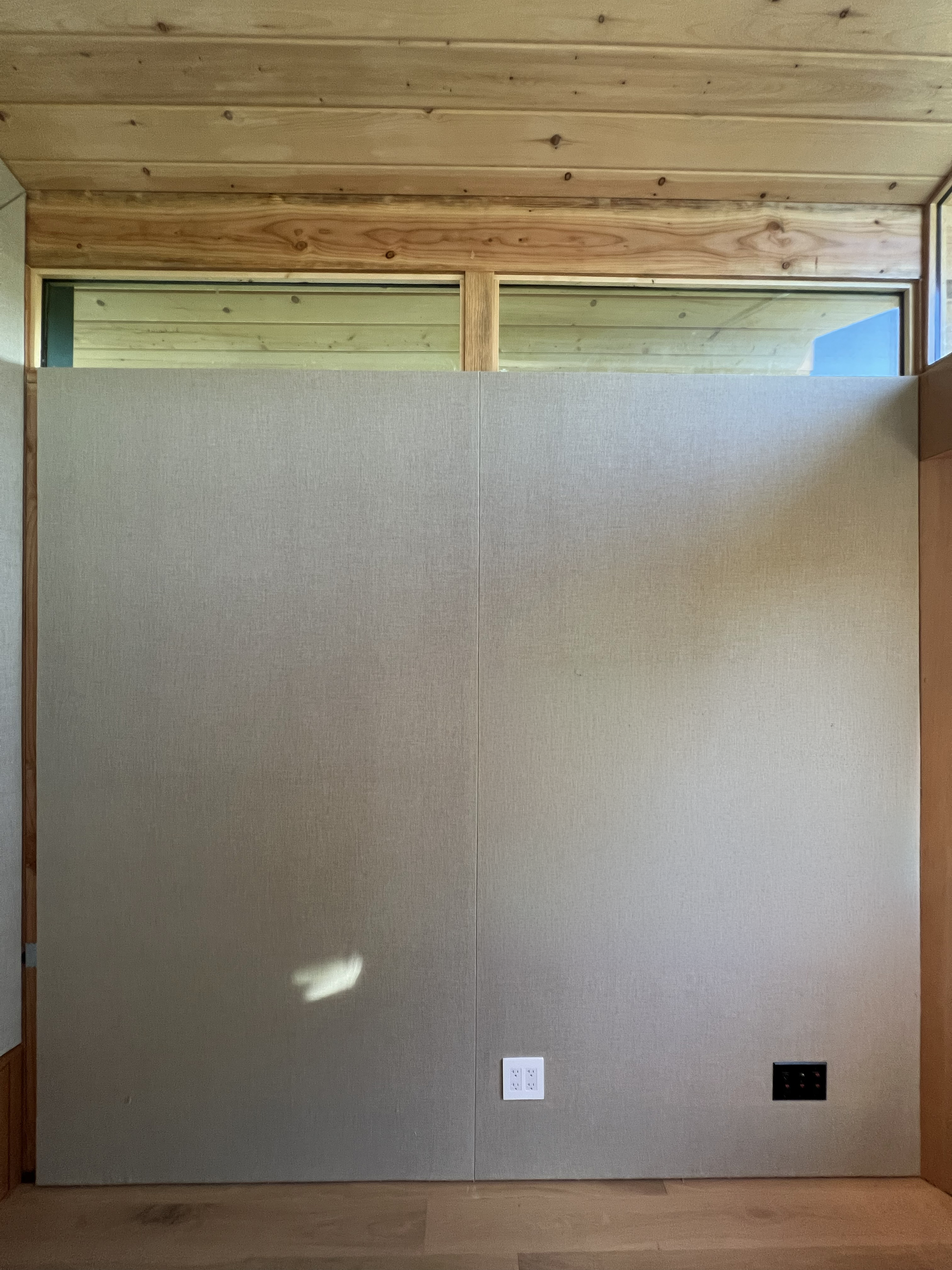 Fabric-wrapped walls conceal a highly tuned acoustic assembly, allowing the studio to achieve professional performance without the visual language of a conventional recording booth.
