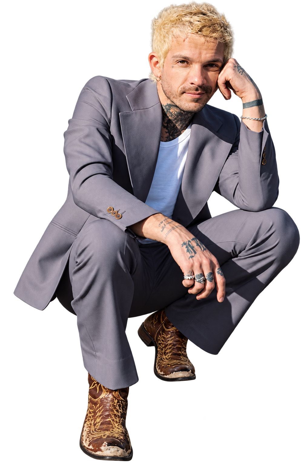 Salvador "Sal" Salcedo, Los Angeles hairstylist and founder of Nova Arts Salon, seated in a gray suit against an orange background.