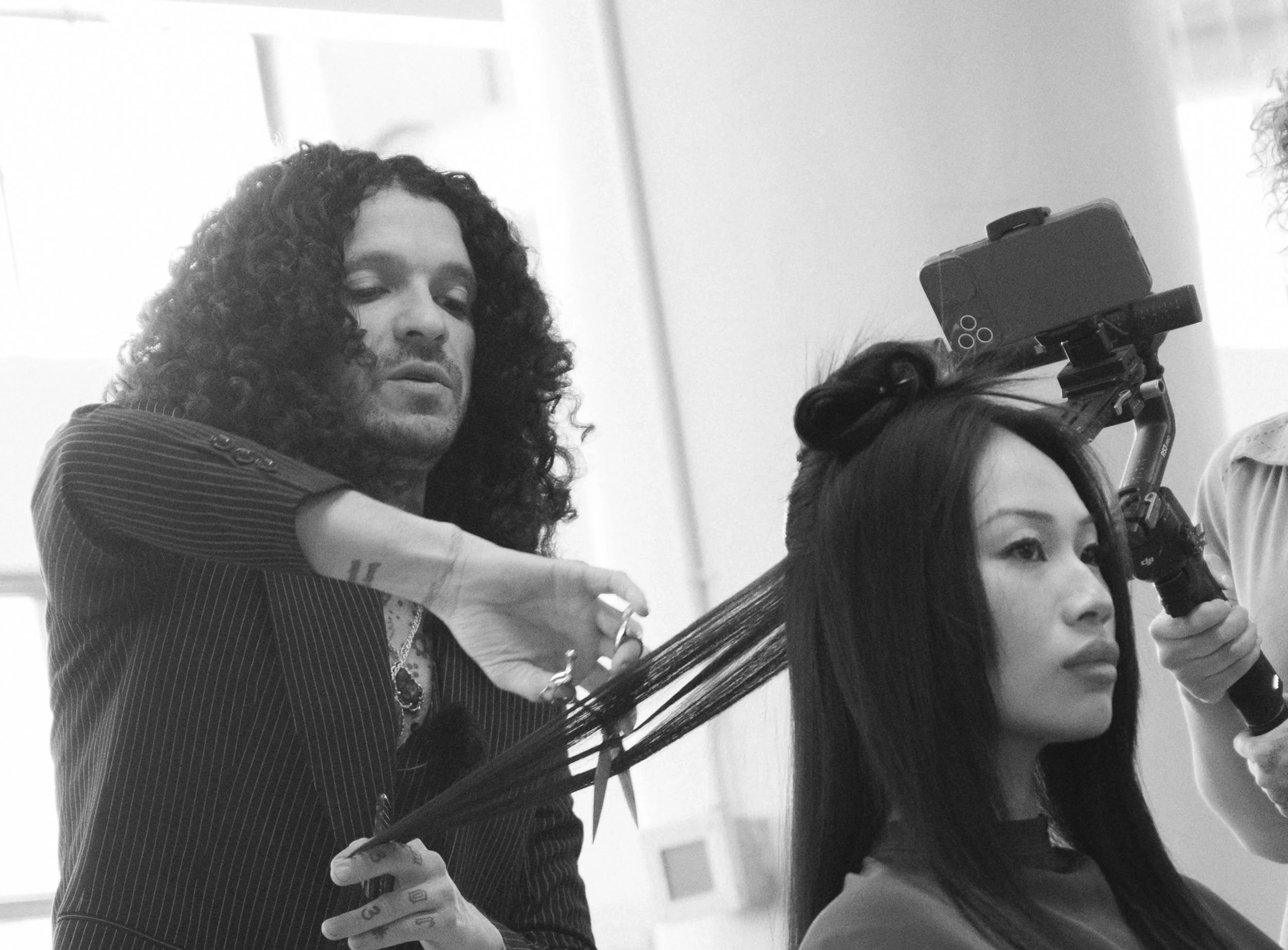 Sal Salcedo demonstrating his haircutting techniques while cutting a model's hair during an in-person hair education session.