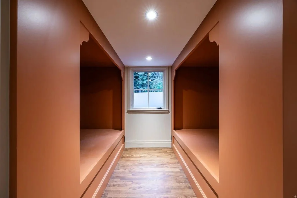 Small room with built-in wooden bunks on each side and a window at the end.