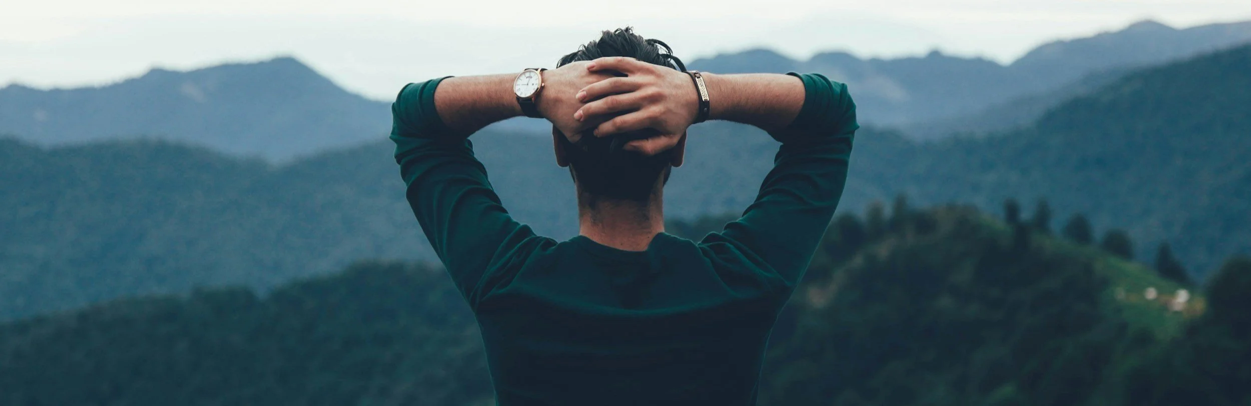 Person overlooking mountains in a relaxed pose