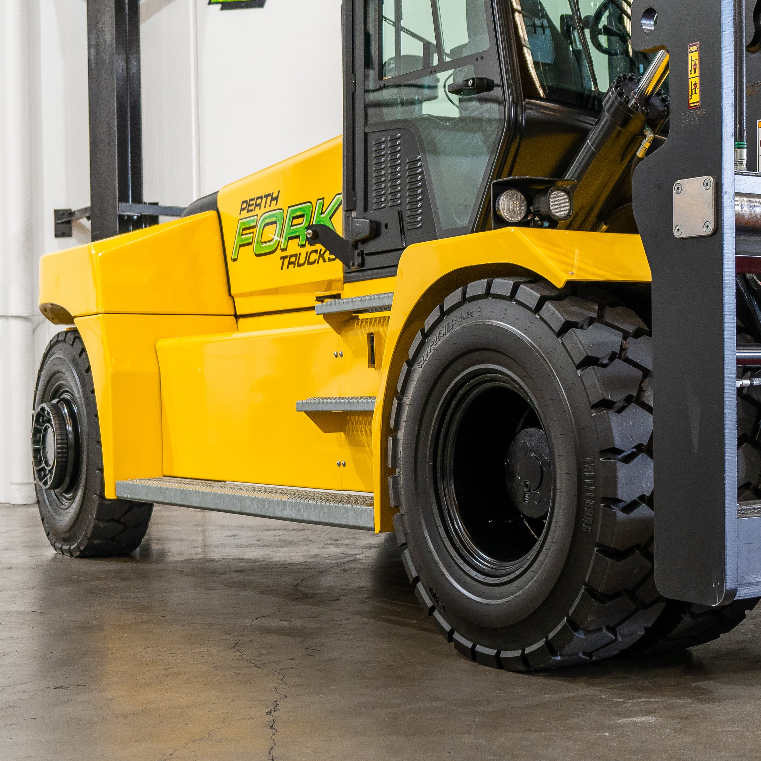 Close-up view of a yellow forklift truck in an industrial setting.