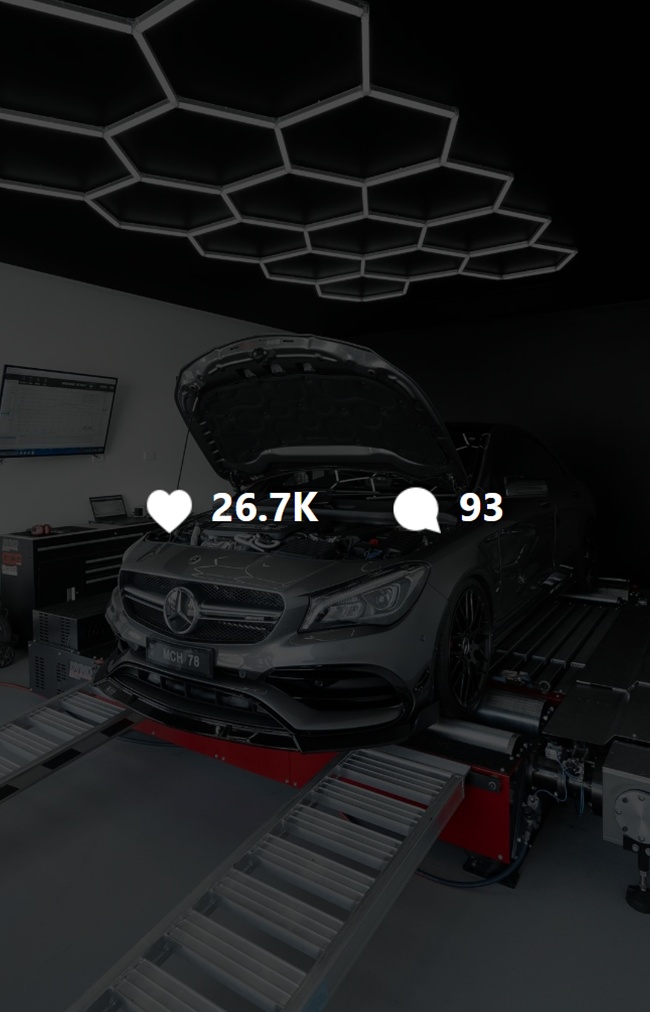 A thumbnail of a video of a gray Mercedes-Benz car with its hood open on a dynamometer testing machine in an automotive laboratory with contemporary hexagonal LED ceiling lights. The video has 26.7k likes and 93 comments on the Instagram UI.