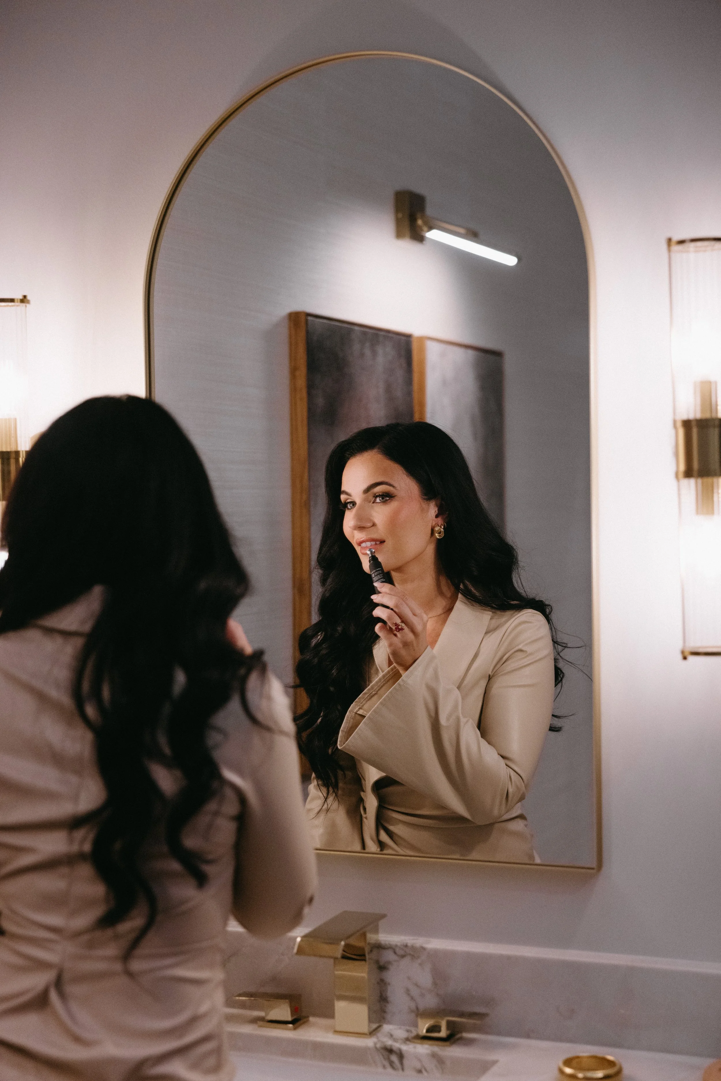 Dark haired woman putting anfisa lip gloss on