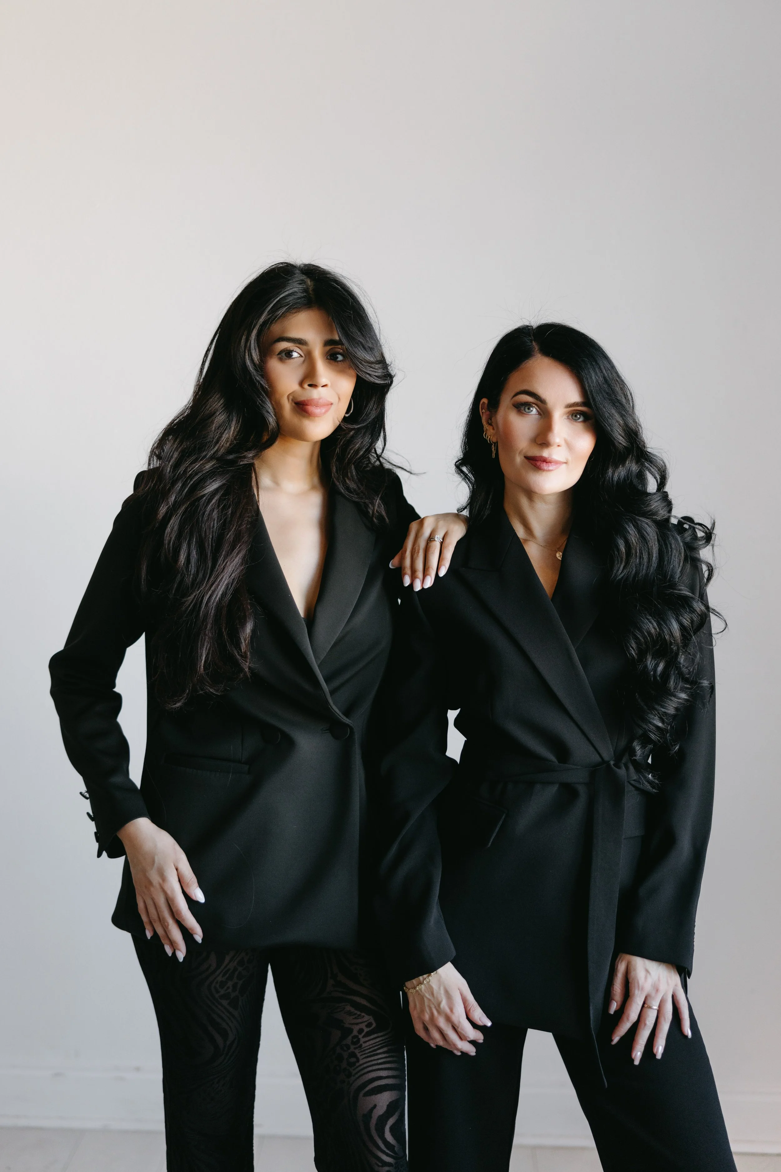 Two women in black business outfits