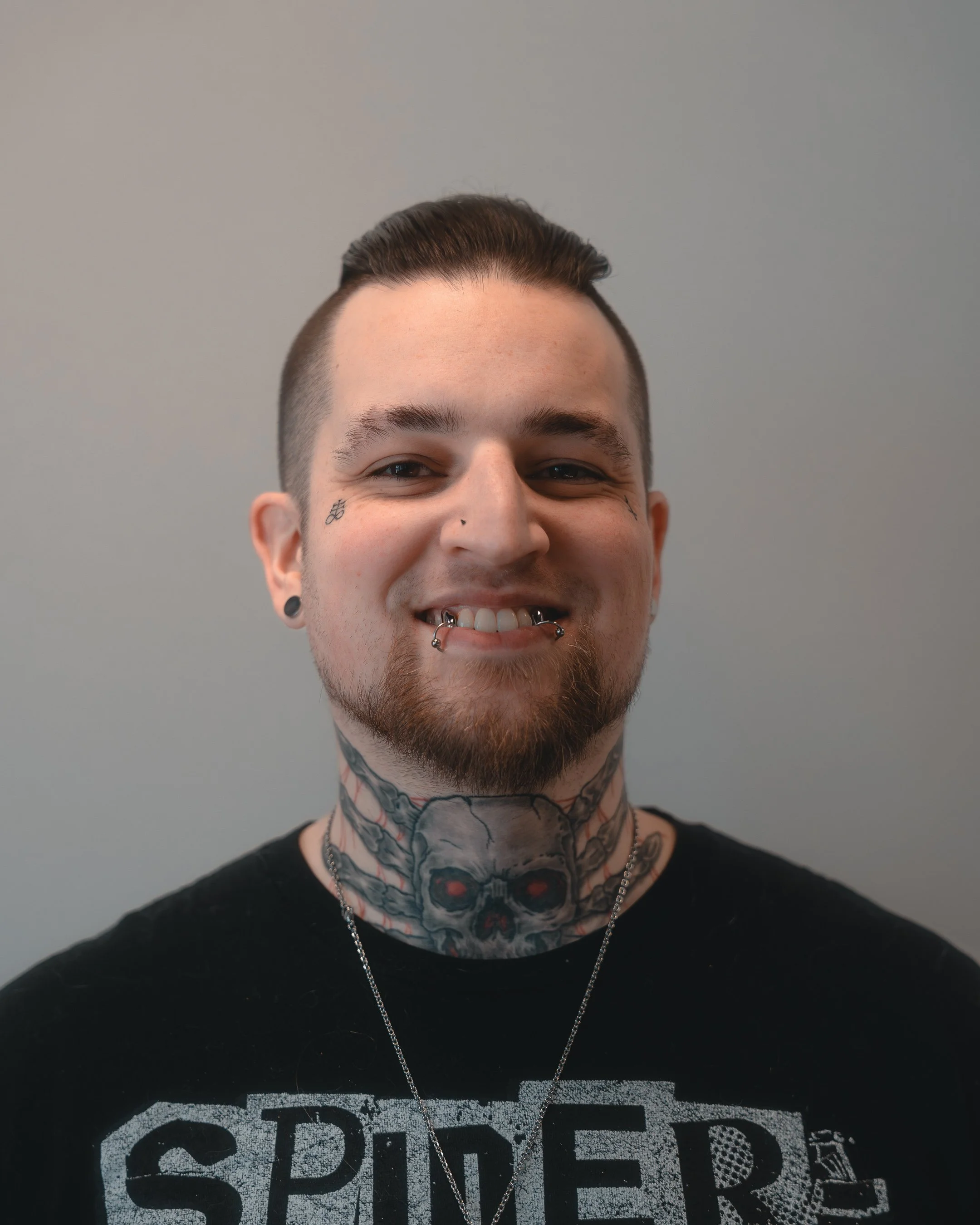 Person with glasses, beanie, and tattoos