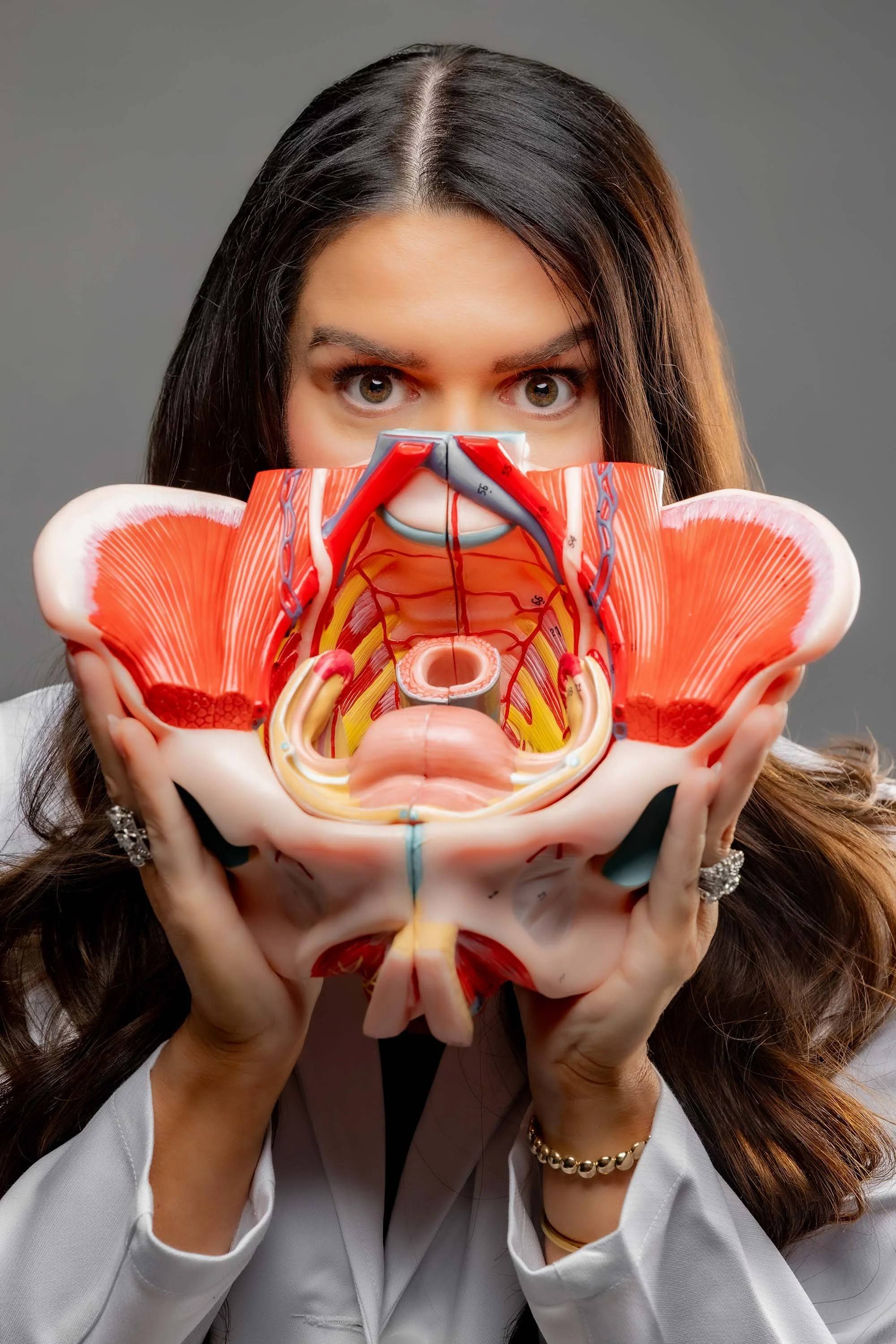 Dr. Jenn Burg holding a model of a woman's anatomy