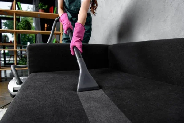 Person deep cleaning upholstery with a wet vacuum.