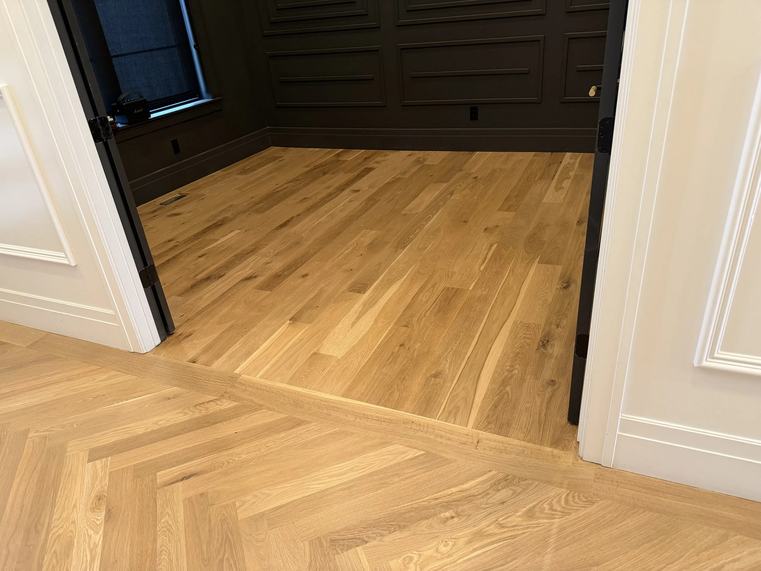 Refinished white oak hardwood showing transition from pattern to traditional installation in an office