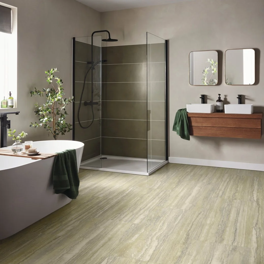Bathroom with a green tiled wall shower in one corner, with the bath facing it on one side and the vanity on the other. 