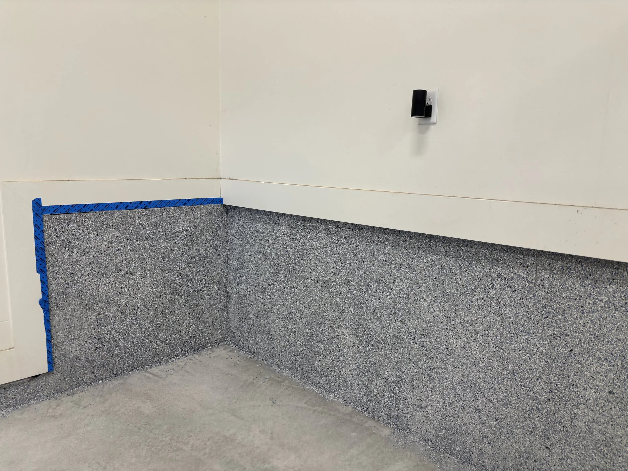 Garage epoxy flecks going up the wall in a corner.