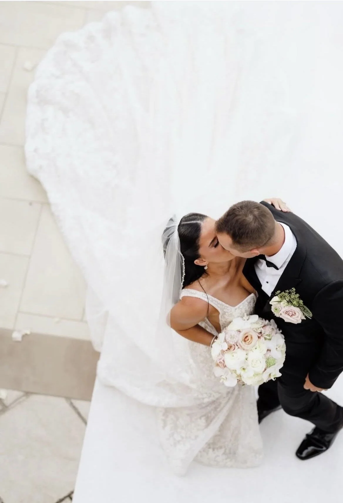 An overhead shot of a bride and groom kissing.