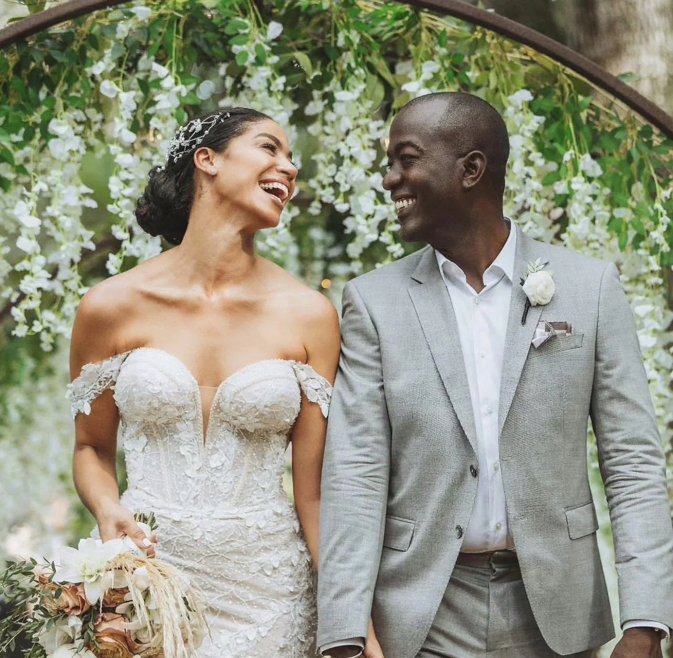 A couple on their wedding day smiling at each other.