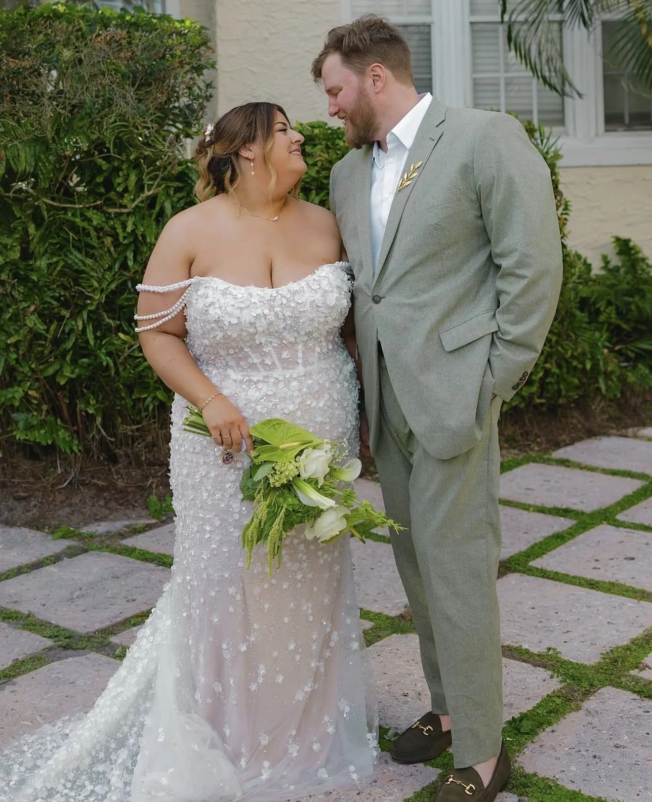 A couple on their wedding day posed looking at each other.