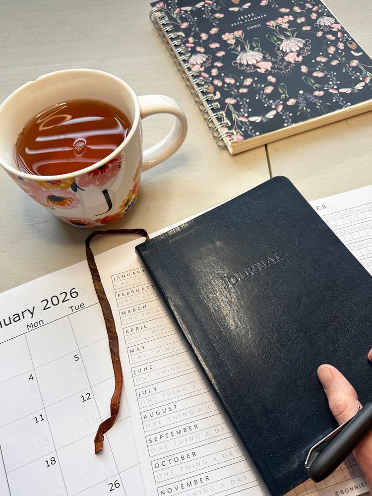 journal next to a cup of tea