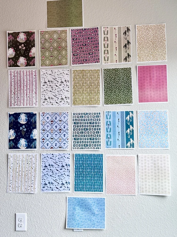 printed patterns on letter sized paper hung up on a wall.