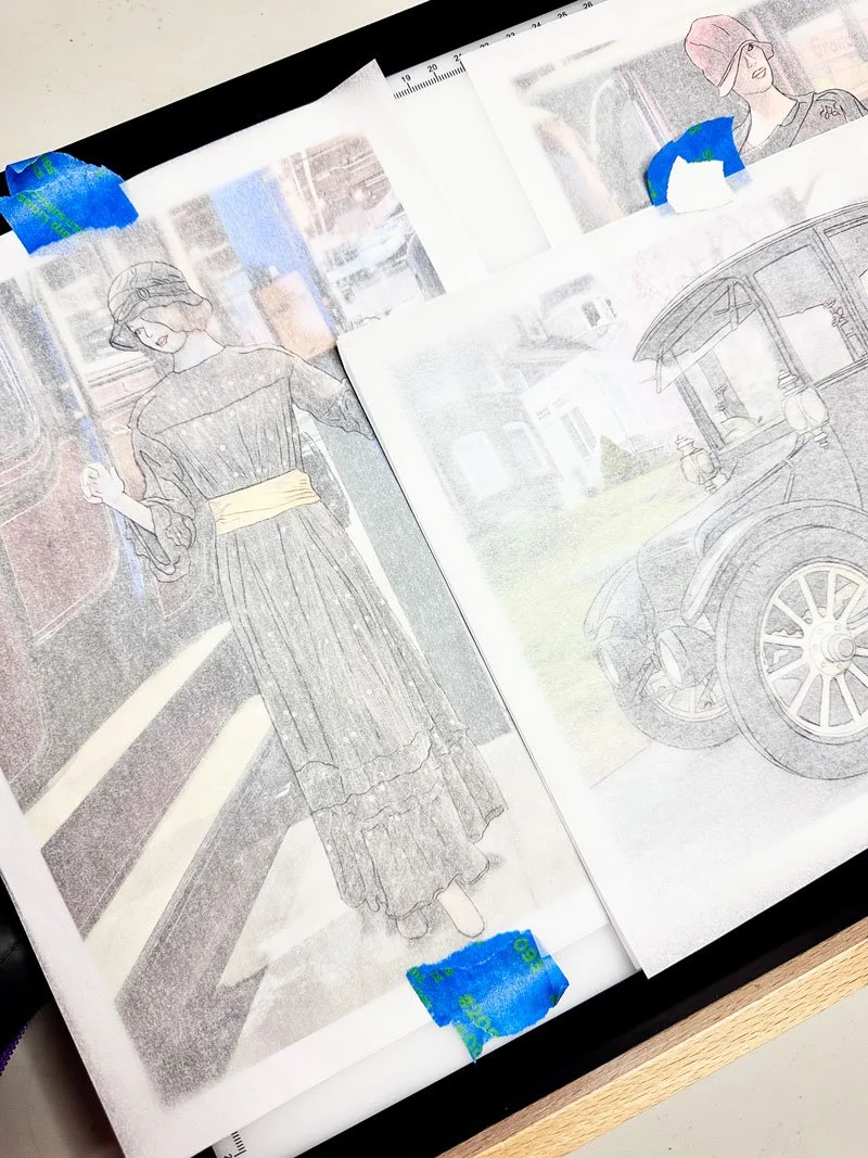 overhead view of a light table with tracing paper over photographs