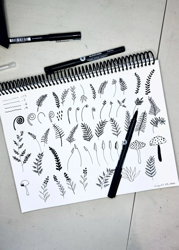 overhead view of a sketchbook with pen sketches