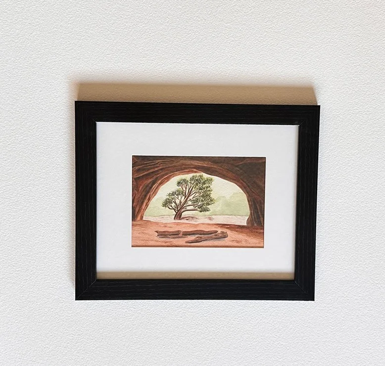 watercolor painting of a scene in utah in a black frame with a white mat