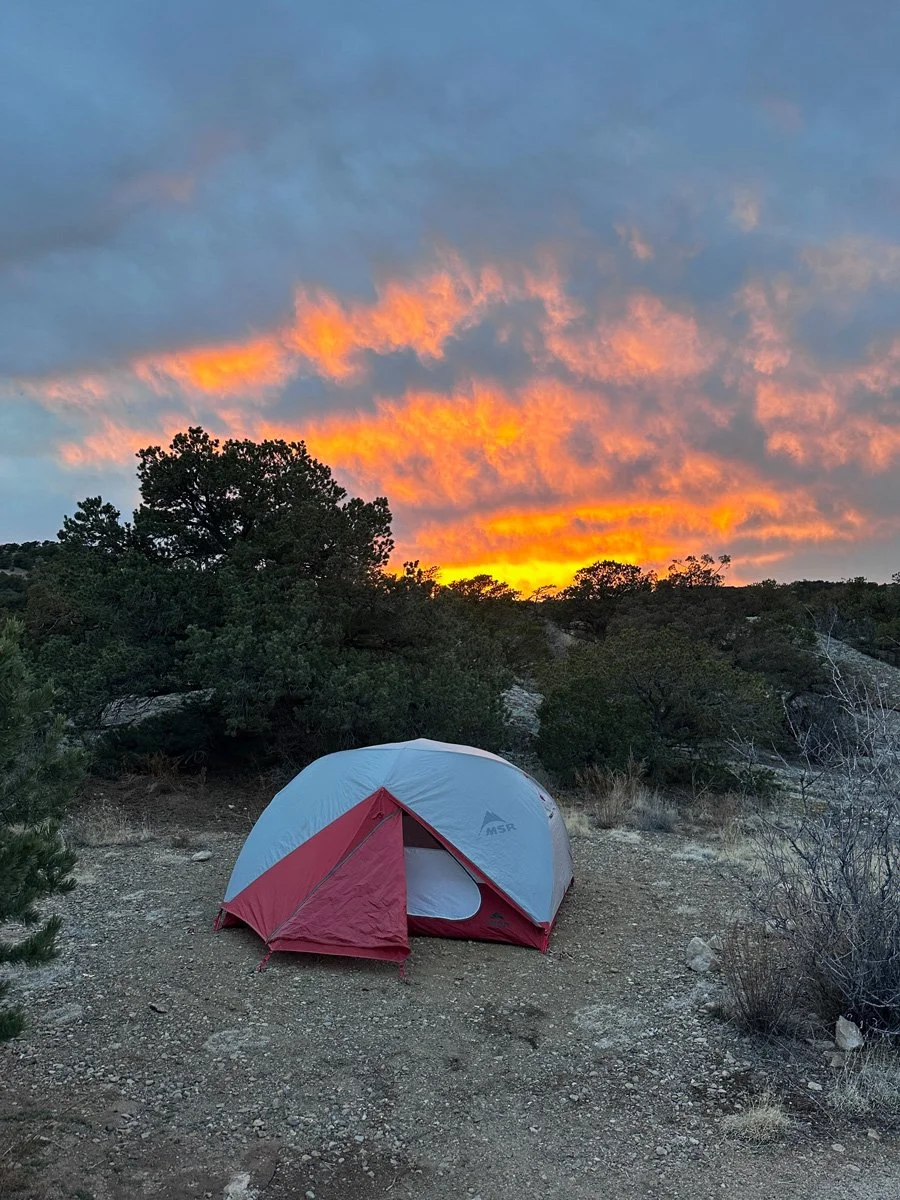 tent with a vibrant sunset behind it