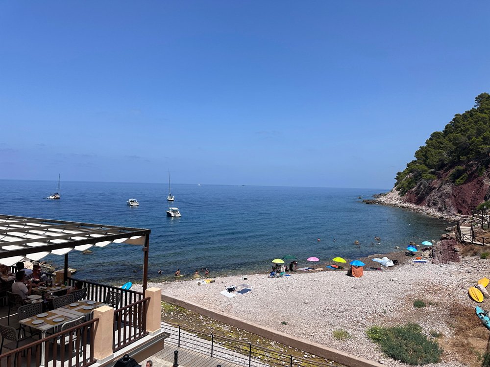 rocky beach on the mediterranean with beach umbrellas