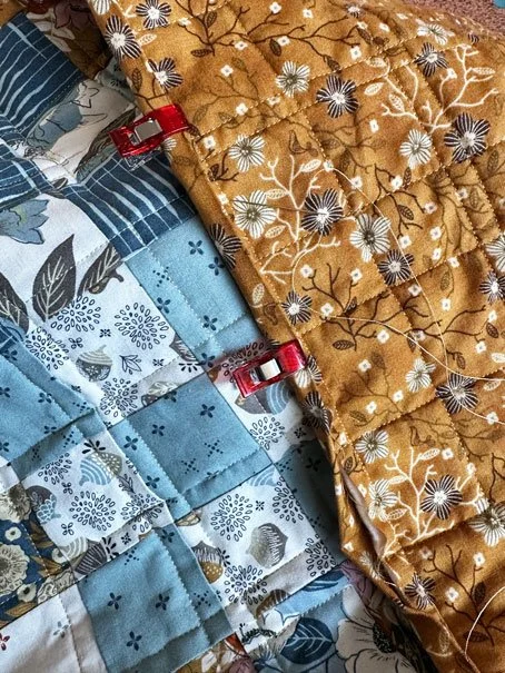 photograph of plastic clips attaching binding to quilt top