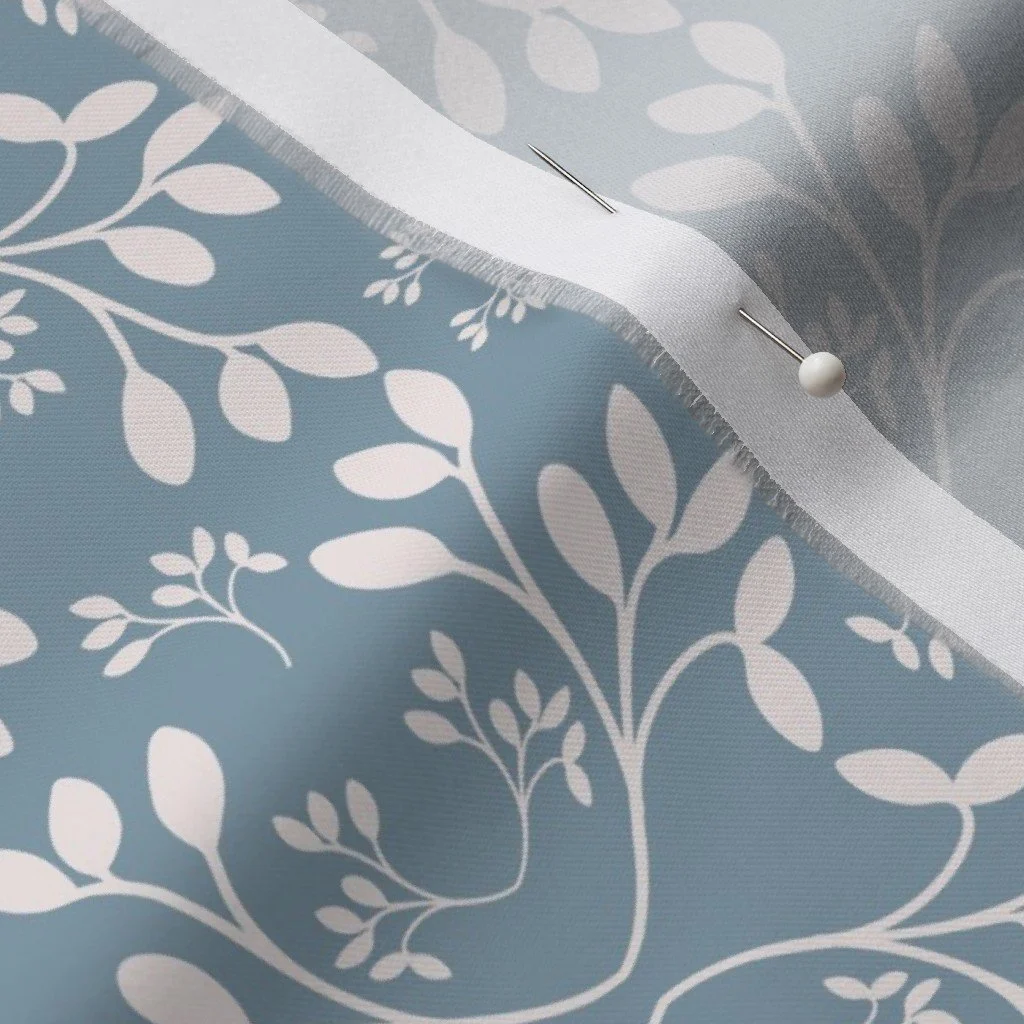 fabric featuring cream colored leaves on a light blue background