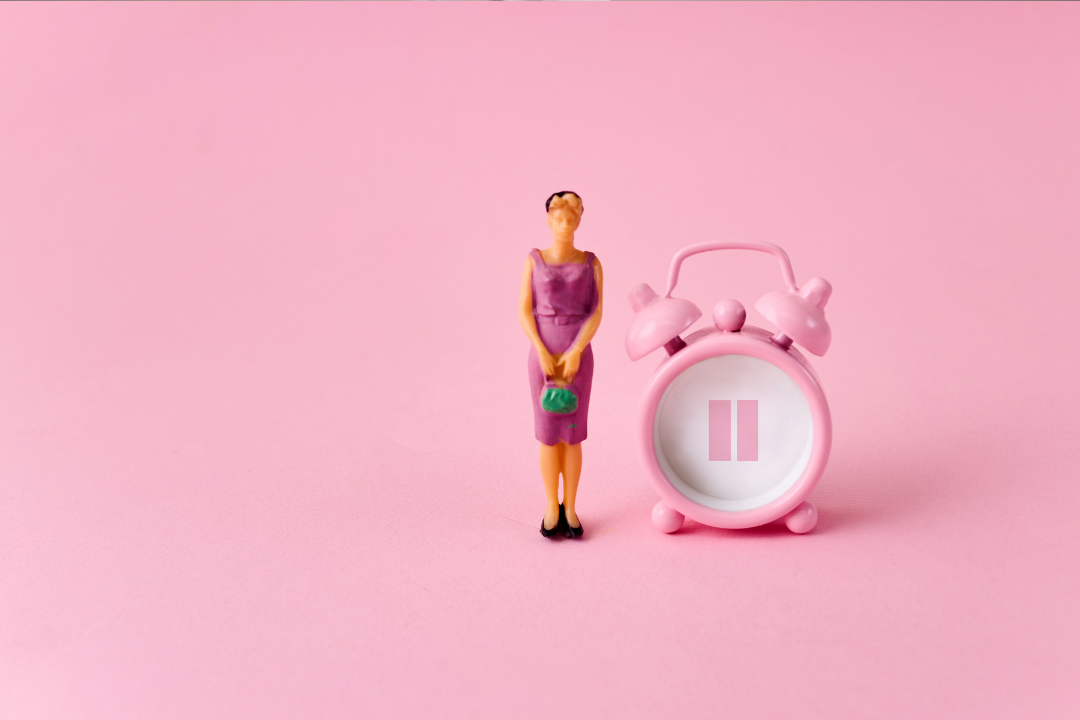female doll standing beside a clock that is paused