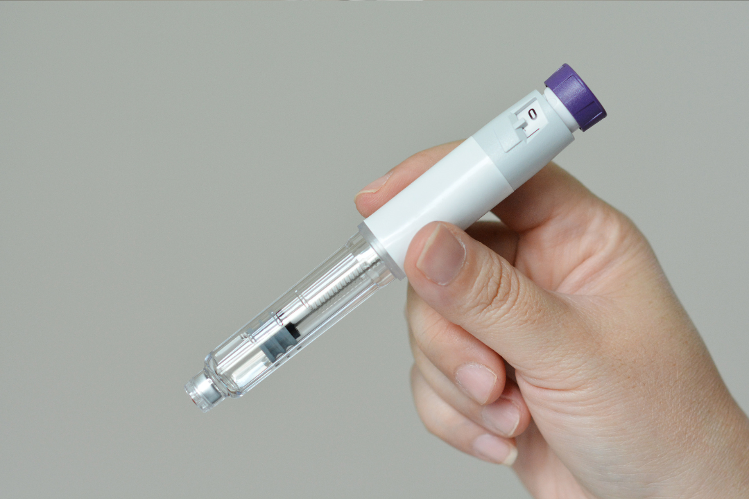 GLP-1 injection pen being held by a hand