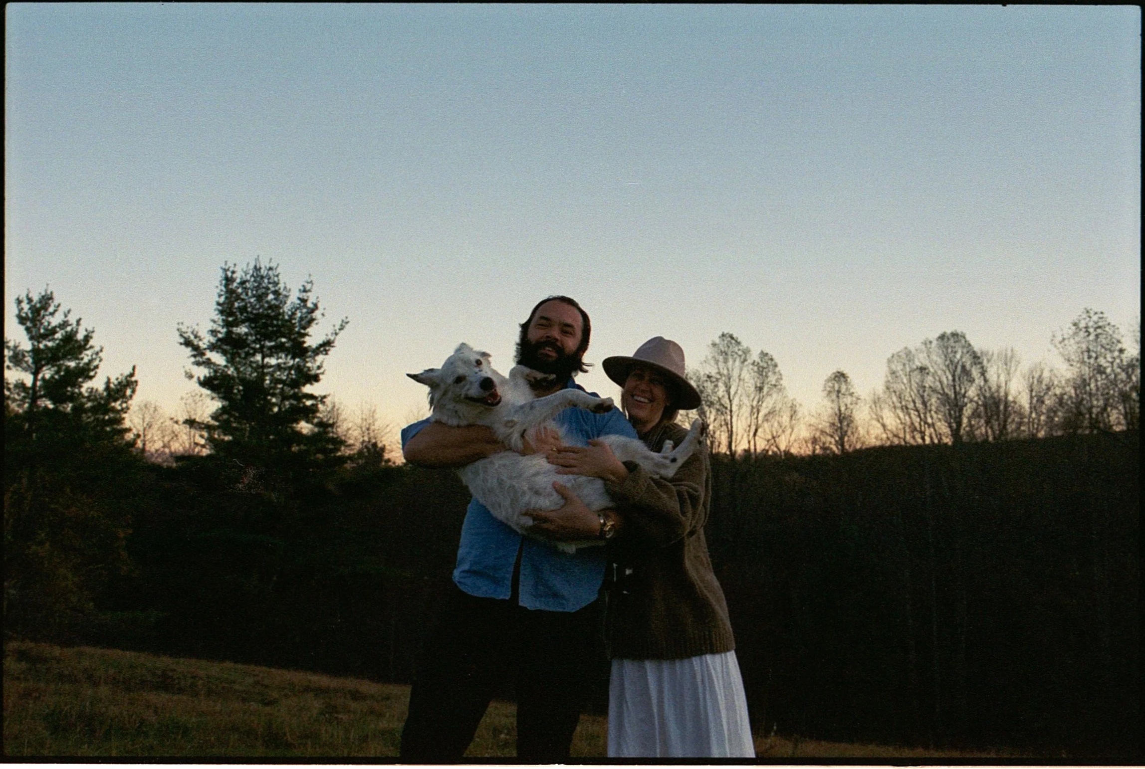 couple posing with their pup in the mountains of nc