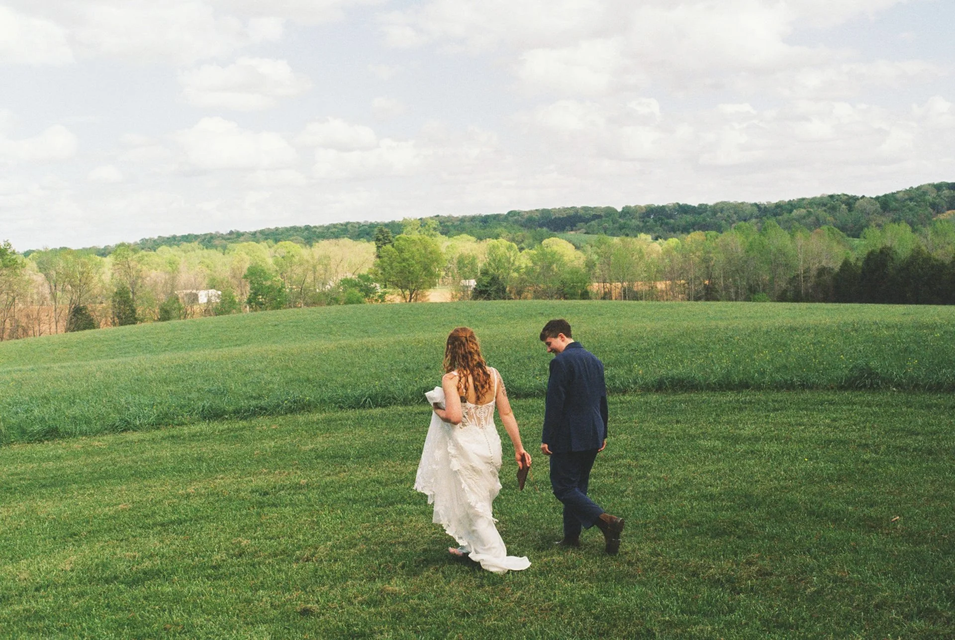couple walking through grass to read private vows