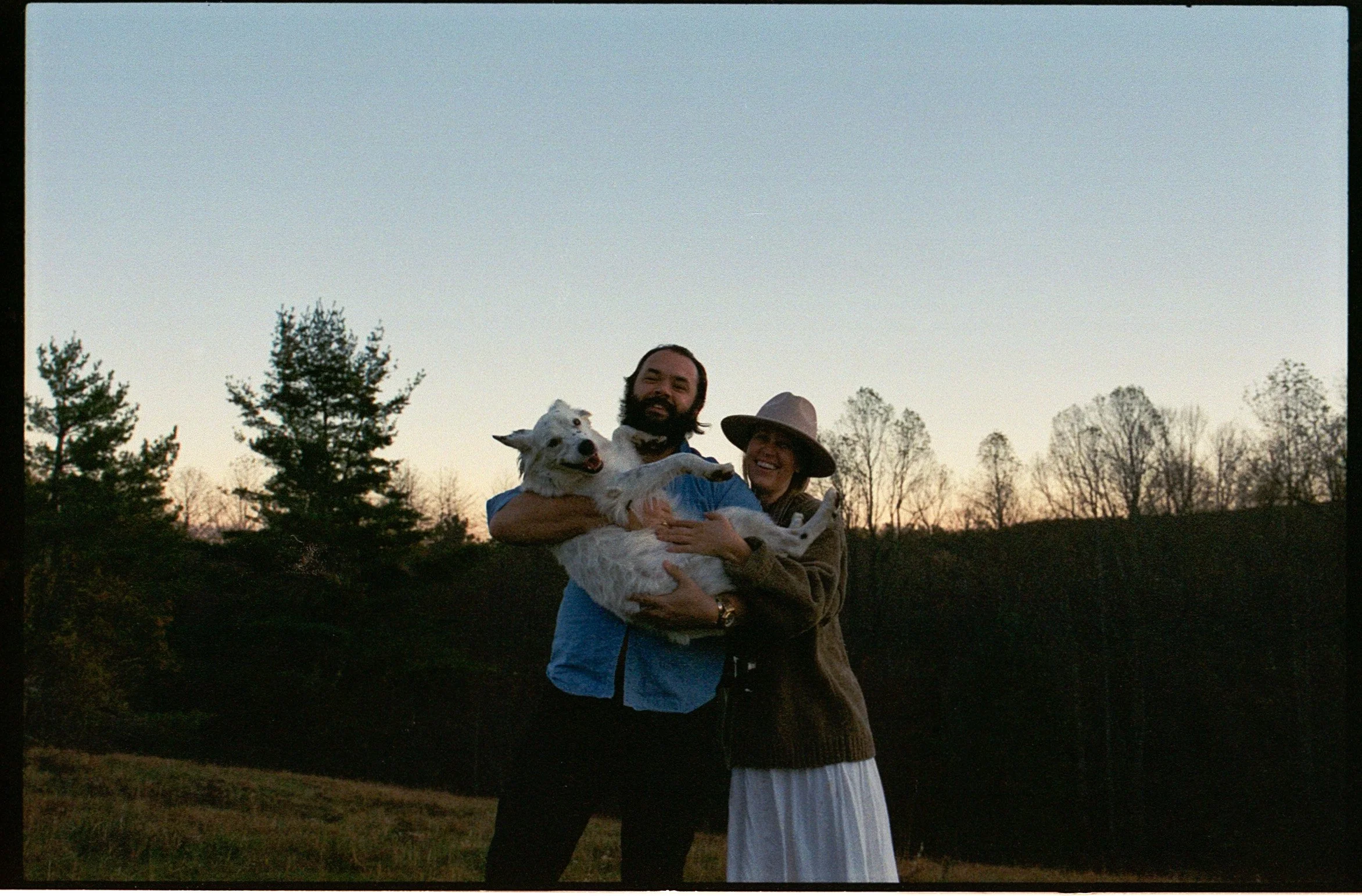 couple posing with their pup in the mountains of nc