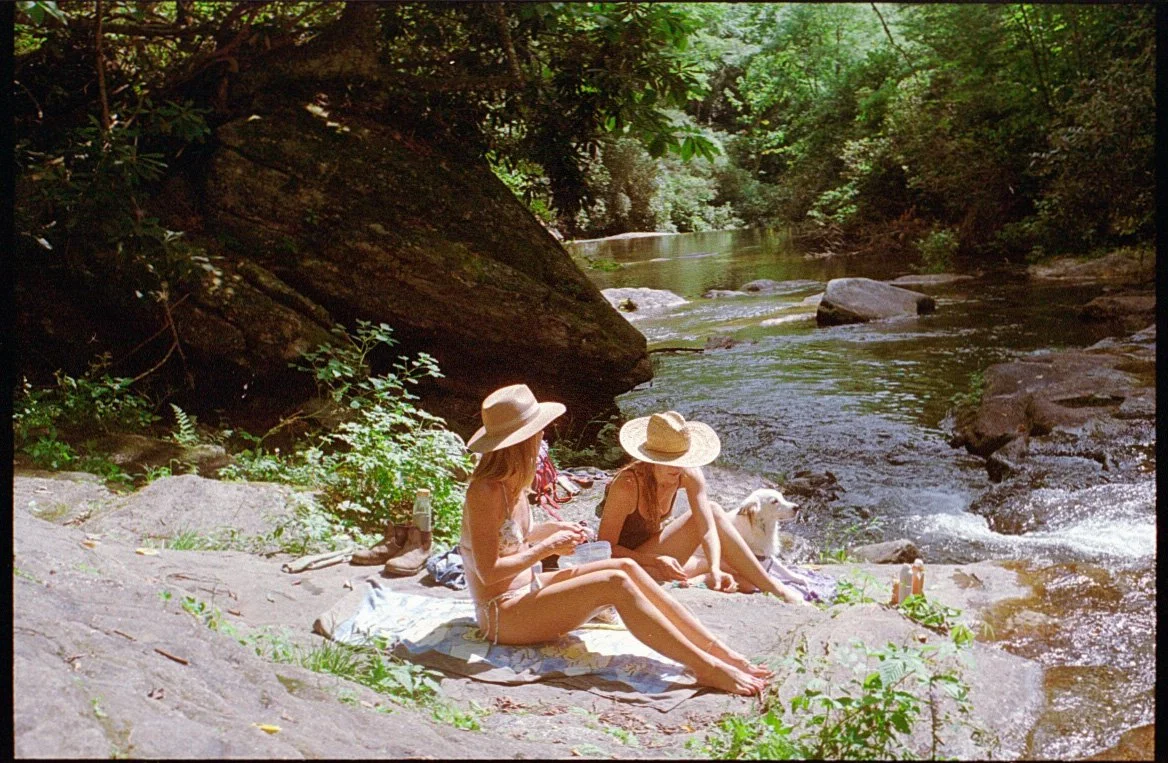 two girls laying by the river in the summer