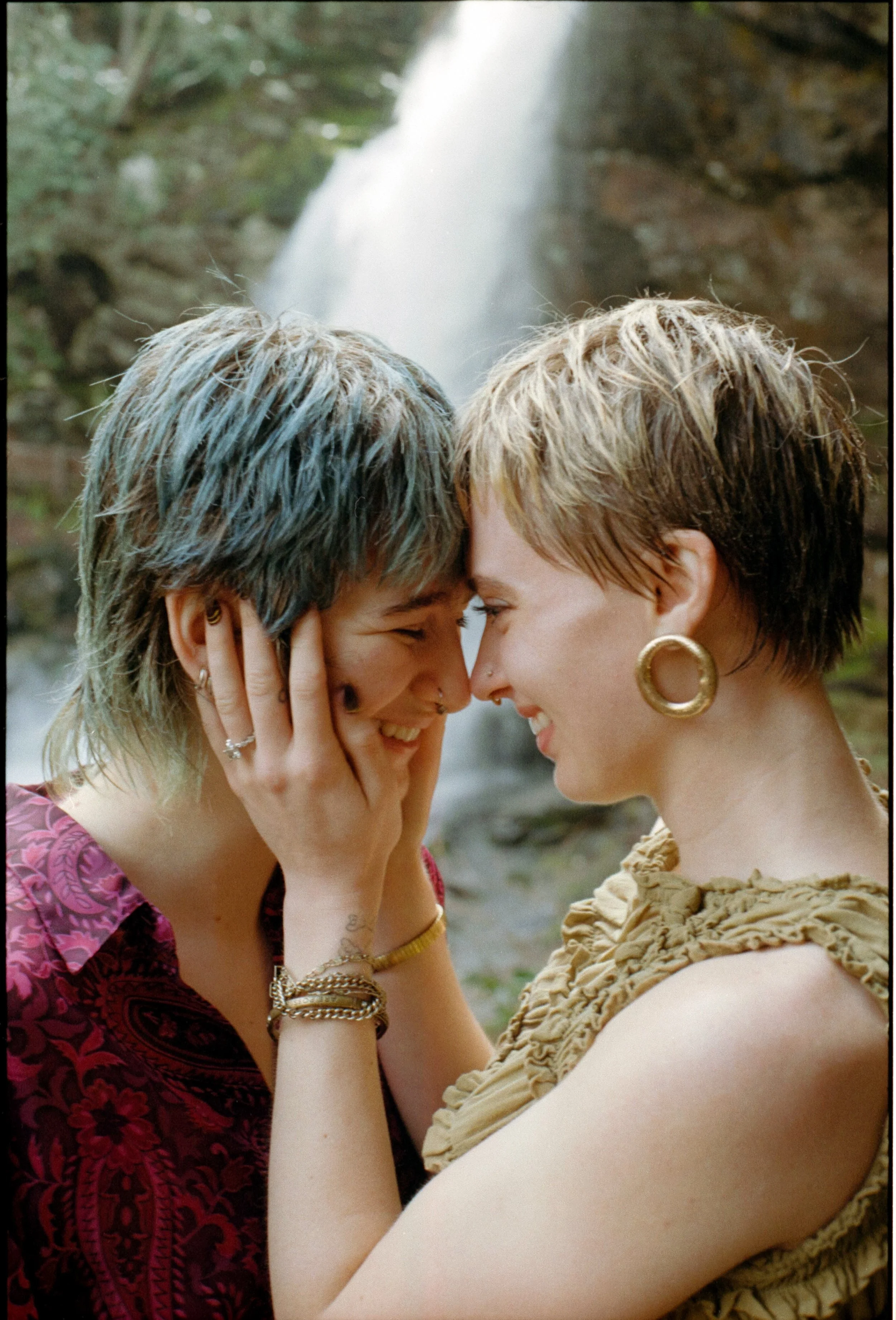couple standing in front of dry falls waterfall lovingly embracing each other and smiling shot on film