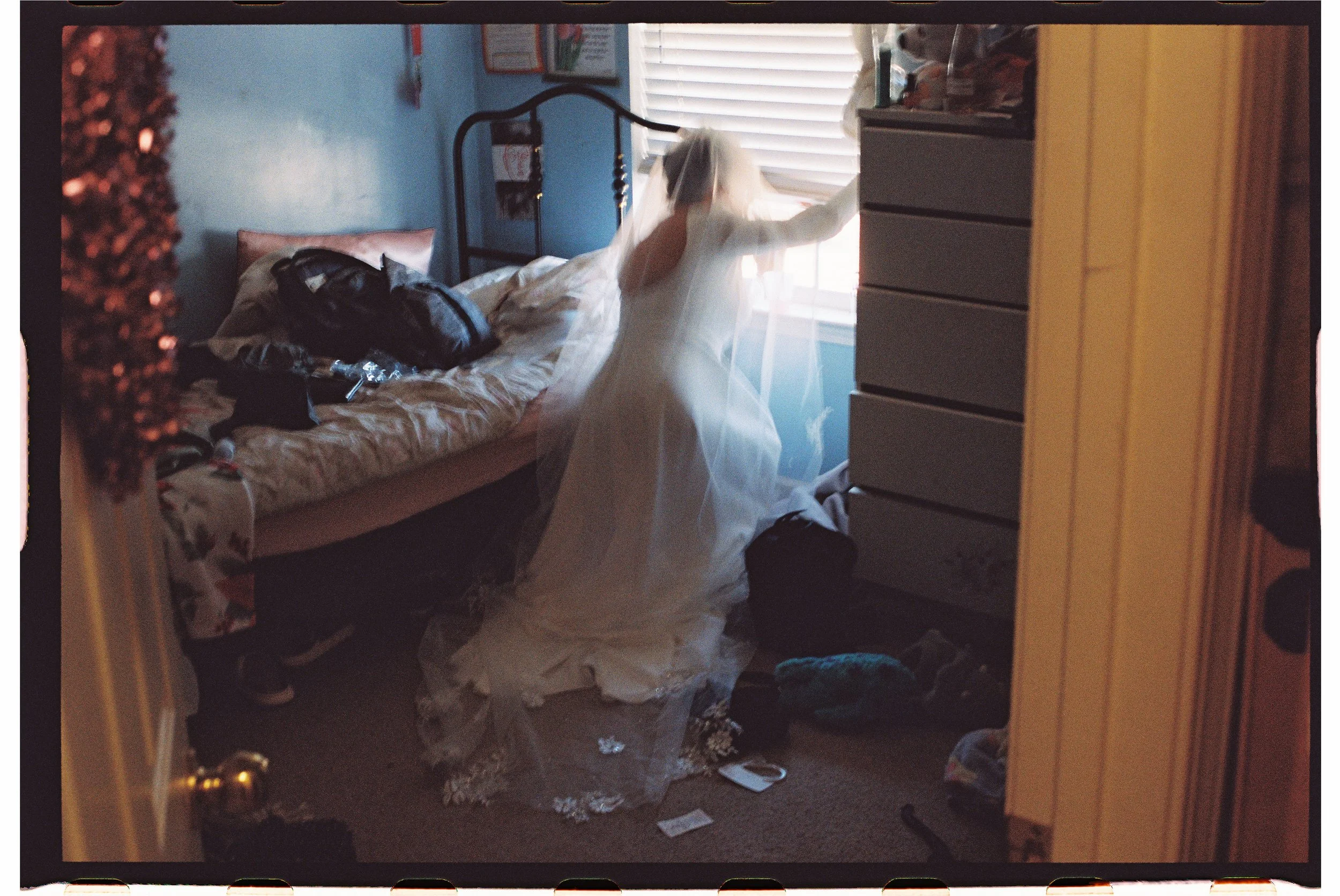 bride looking out her childhood window to guest arriving