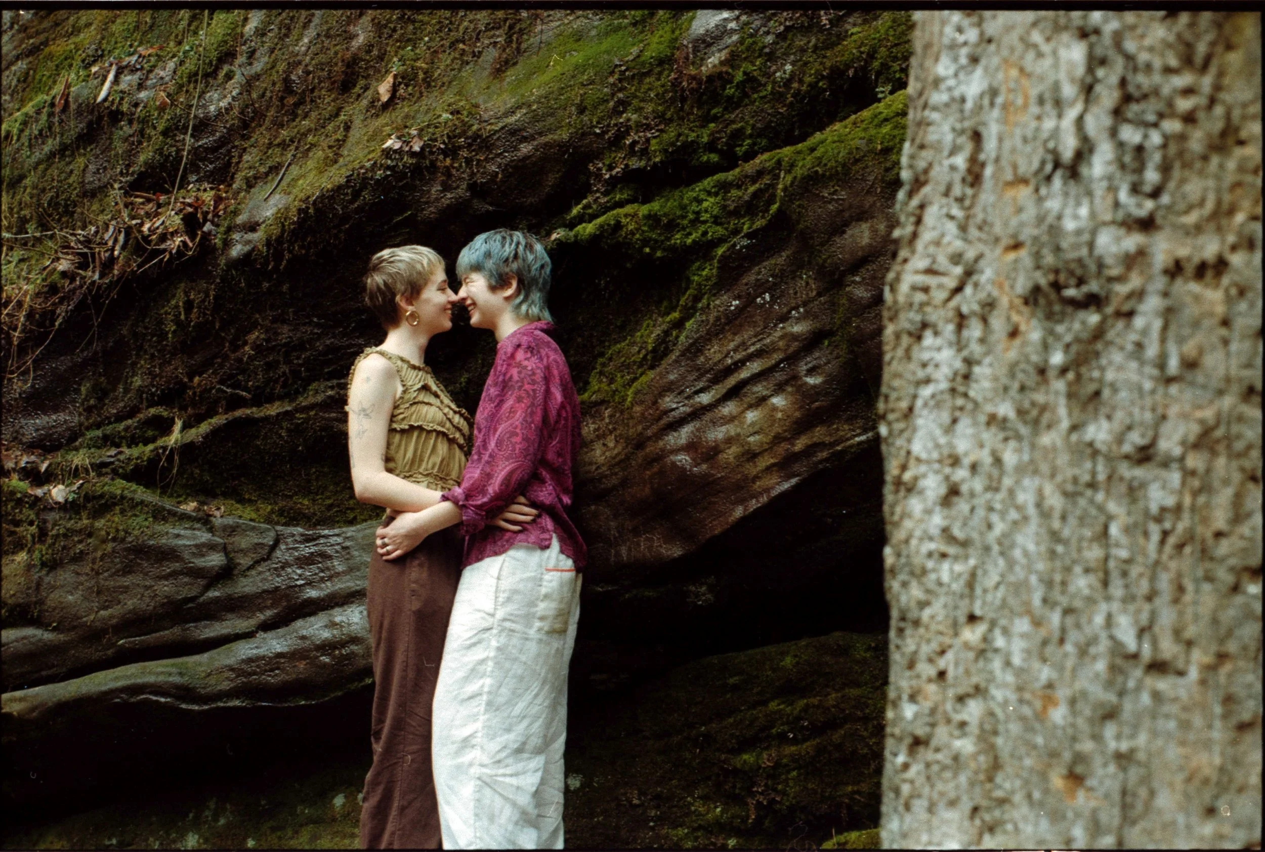 couple lovingly embracing during waterfall engagement shoot in highlands north carolina