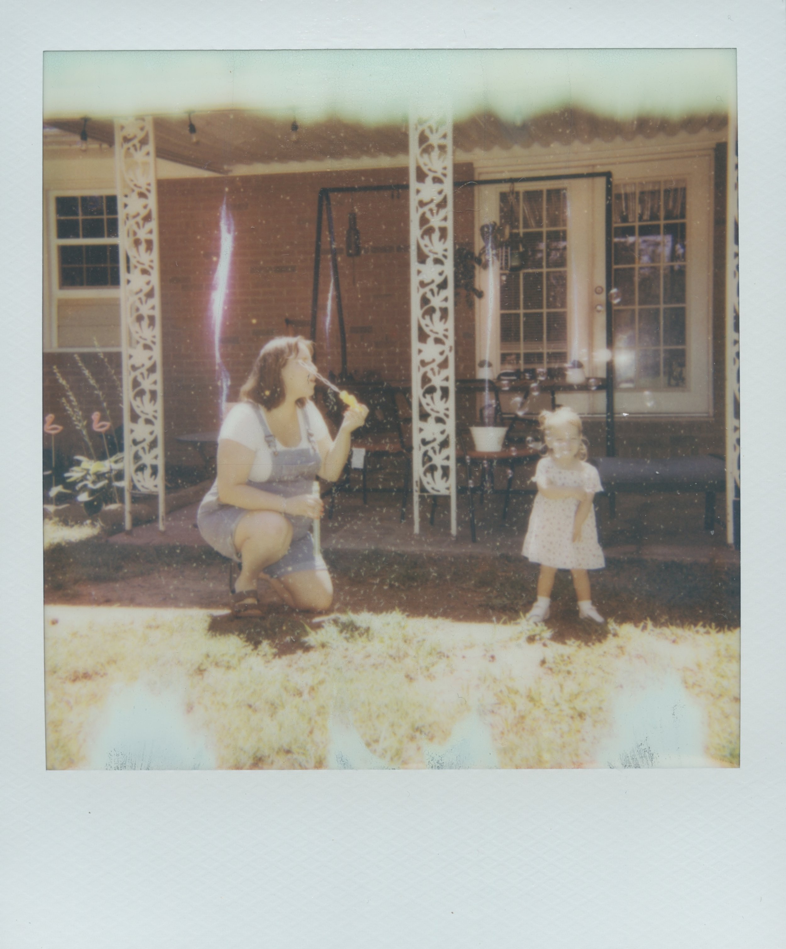 mother and daughter blowing bubbles on a summer afternoon