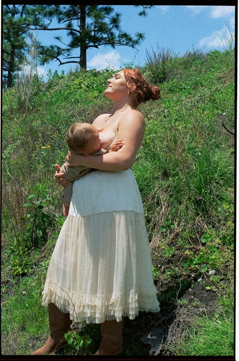 mother breastfeeding child during warm empowering motherhood session on film