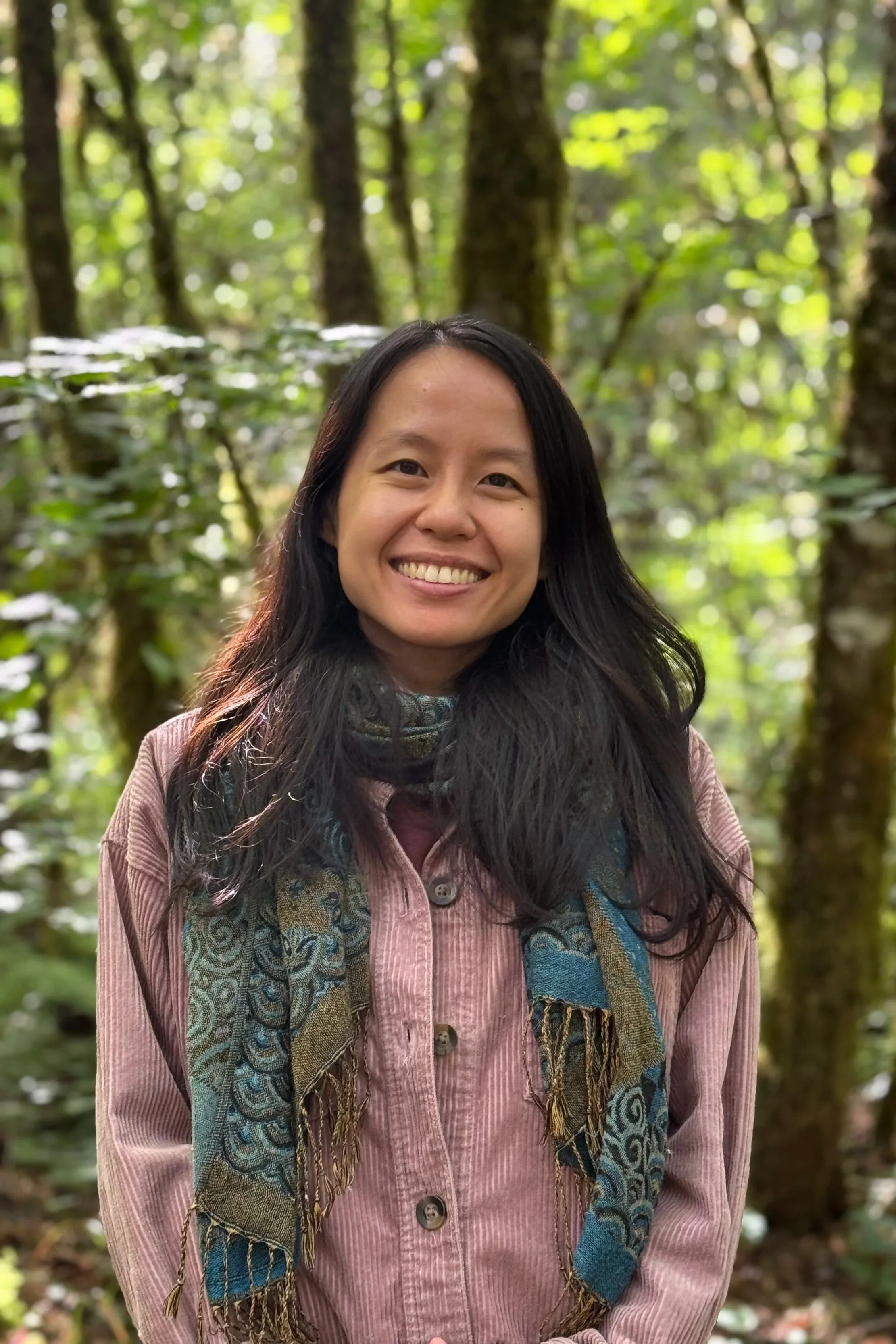 liz zhou, therapist in colorado, smiling in forest