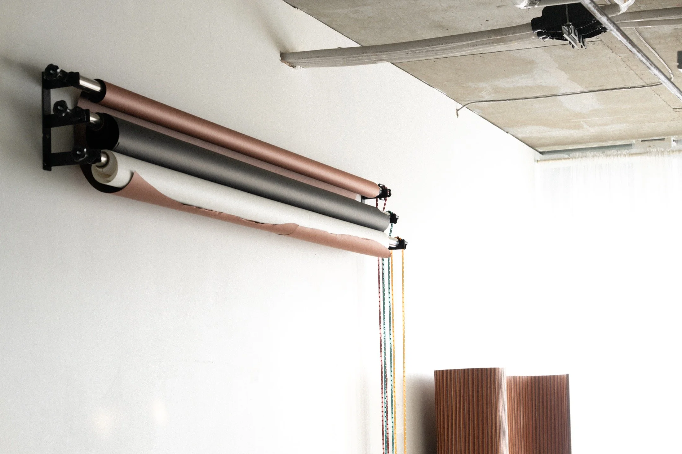 Wall-mounted seamless backdrop rolls and studio window light.