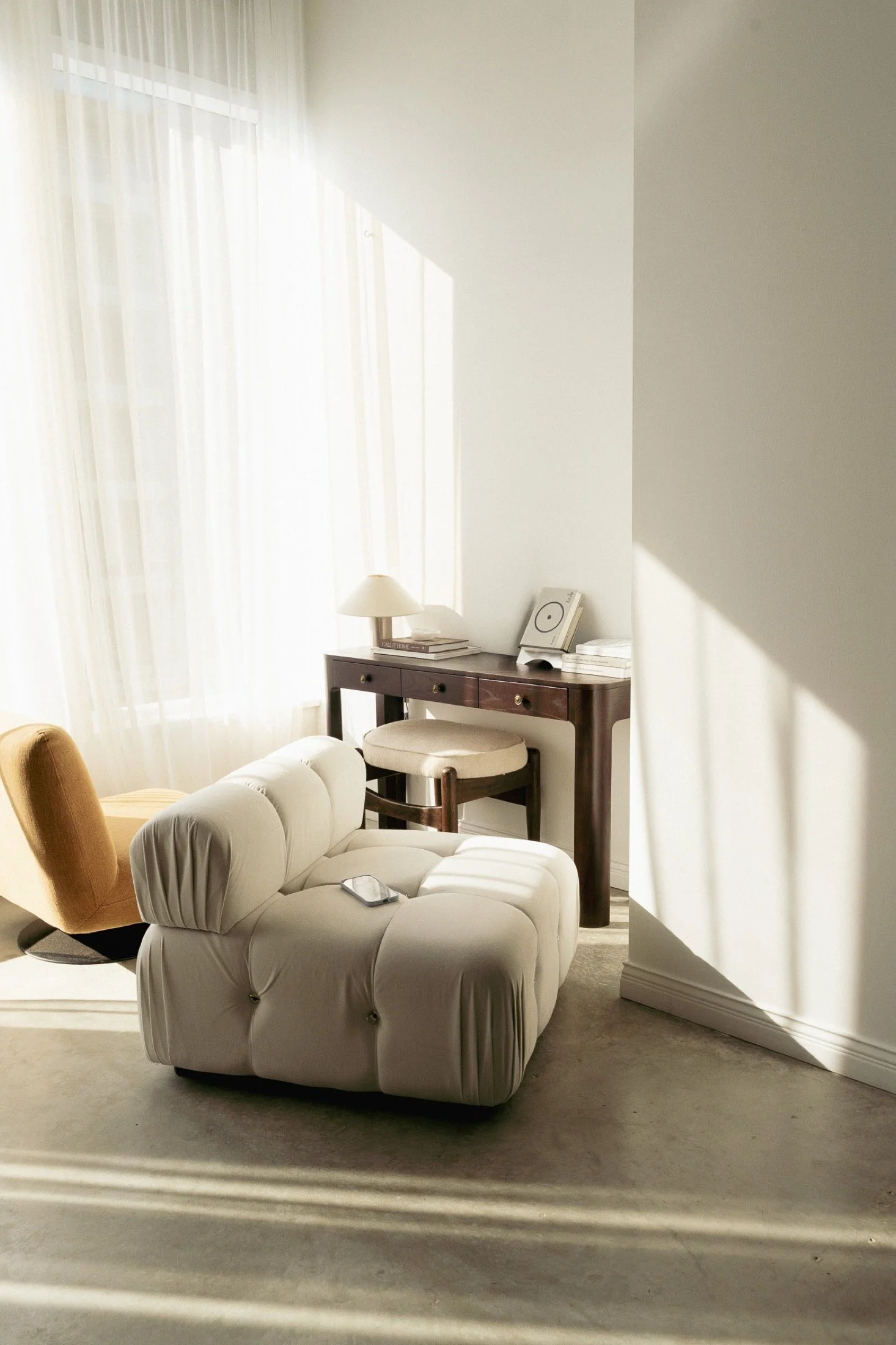 Sunlit desk corner with cream and ochre seating at Studio by VOIR.